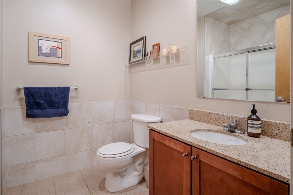 160 Fremont Street, Unit 405 Worcester, MA 01603 - Photo 26 of 34 a bathroom with a toilet a sink and mirror