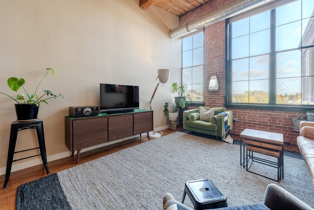 160 Fremont Street, Unit 405 Worcester, MA 01603 - Photo 4 of 34 a living room with furniture and a flat screen tv