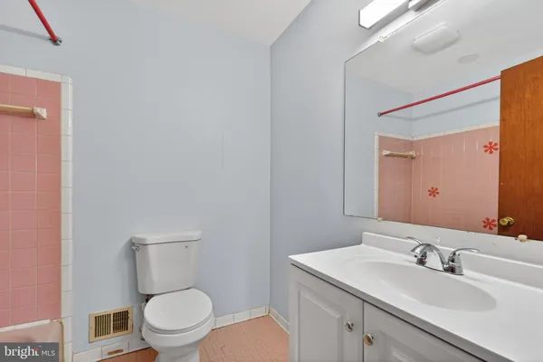 a bathroom with a toilet sink vanity granite and mirror