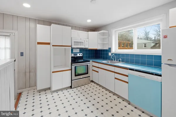 a kitchen with a refrigerator and white cabinets