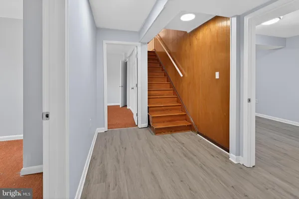 a view of a hallway with wooden floor and stairs