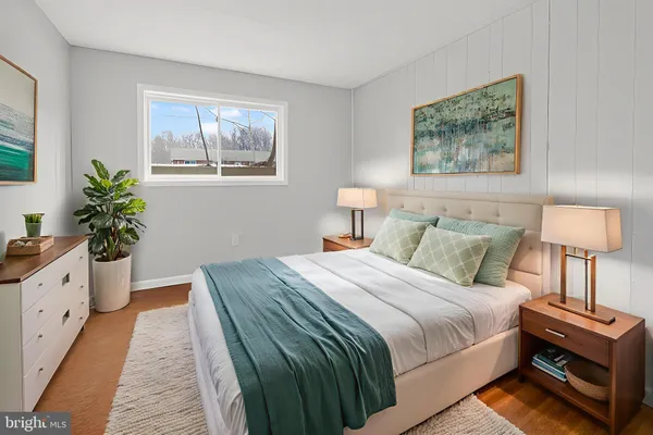 a bed room with a bed and a lamp on dresser