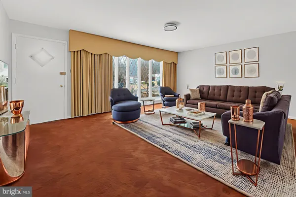 a living room with furniture a rug and a window