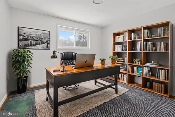a view of a workspace with a bookshelf and a workspace