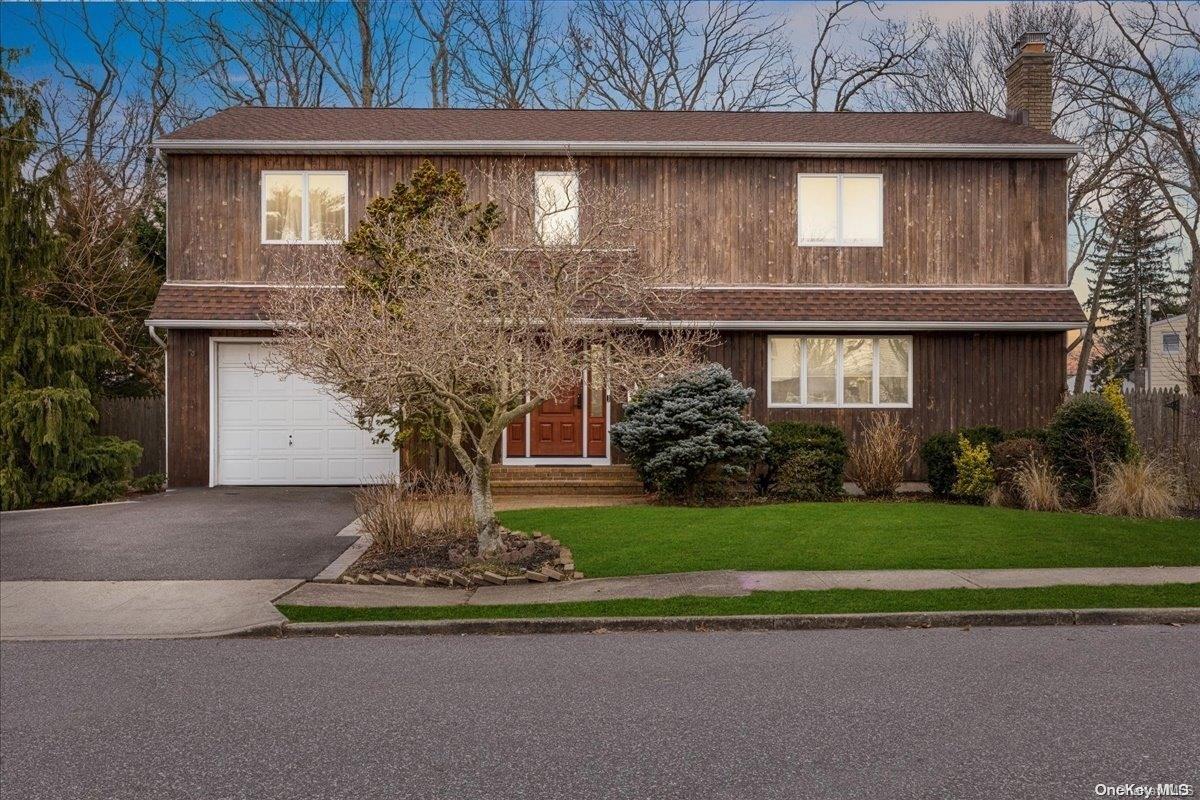 8 Reeves Avenue Farmingdale, NY 11735 - Photo 1 of 1 a front view of a house with a garden and trees