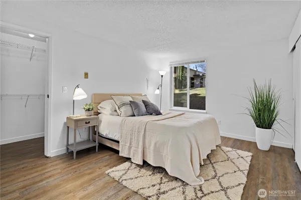 a bedroom with a bed table and a potted plant