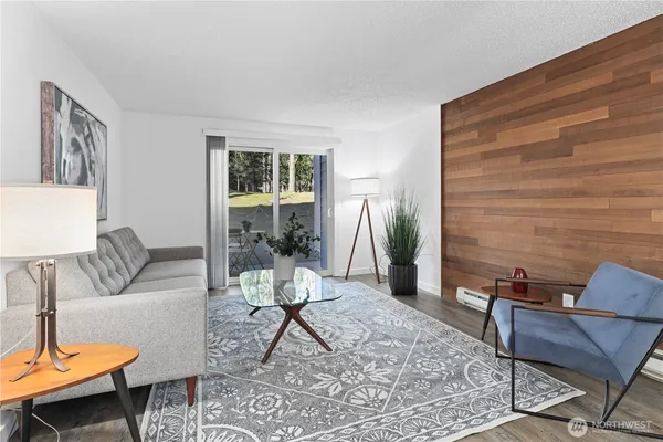 a living room with furniture potted plant and a wooden floor