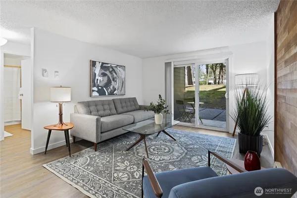 a living room with furniture potted plant and wooden floor