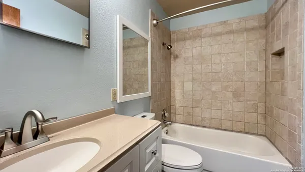 a bathroom with a granite countertop sink toilet and shower