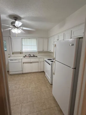 a kitchen with cabinets a refrigerator and a sink