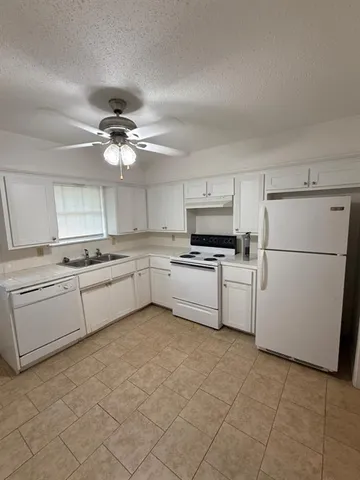 a kitchen with cabinets stainless steel appliances and a window