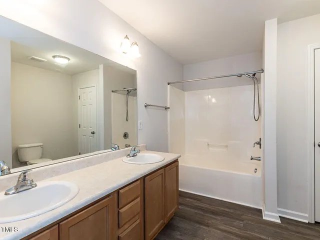 a bathroom with a double vanity sink mirror double and bathtub