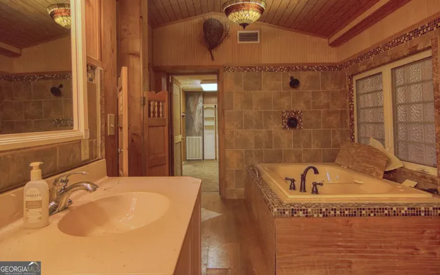 a view of brick house with large windows and a small yard