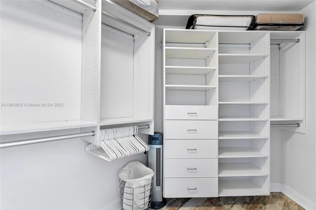 a view of walk in closet with empty racks