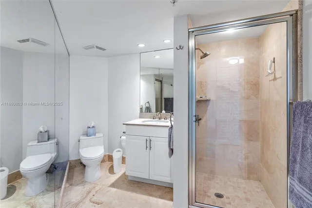 a bathroom with a granite countertop sink toilet a mirror and shower