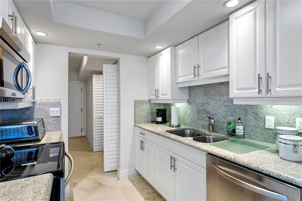 a kitchen with stainless steel appliances granite countertop a sink stove and cabinets