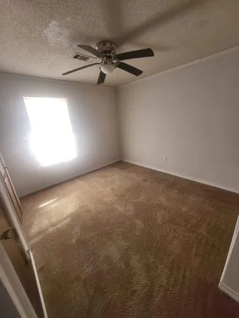 en empty room with windows and fan
