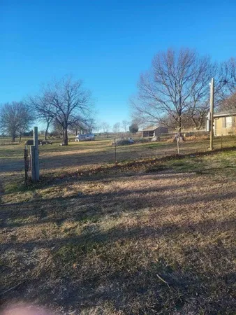 a view of dirt yard with a large tree