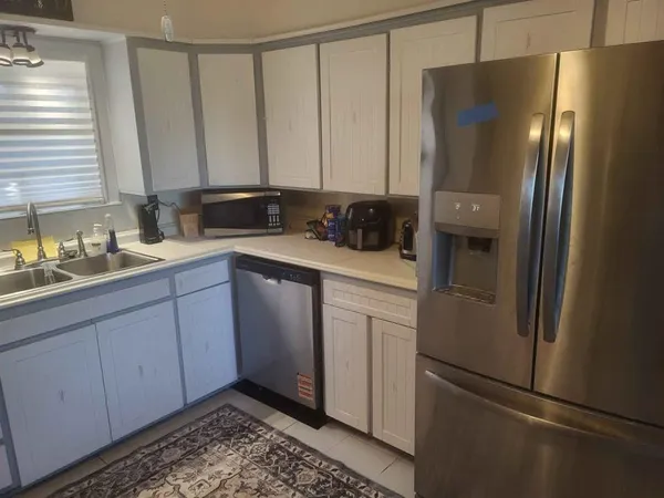 a kitchen with a refrigerator sink and cabinets