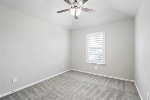 an empty room with chandelier fan