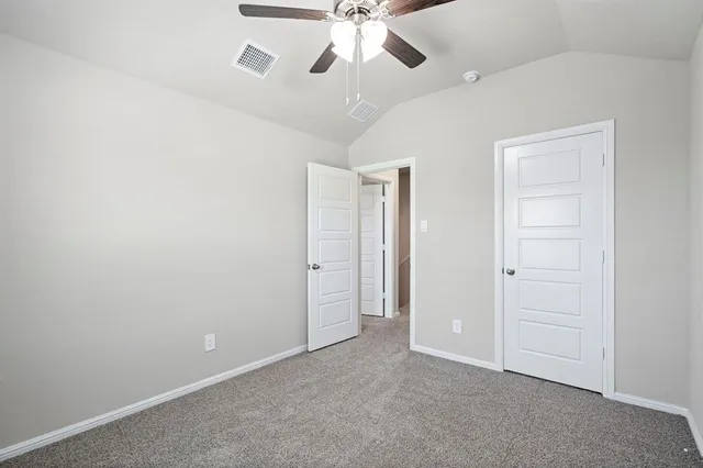 an empty room with a ceiling fan and a bathroom