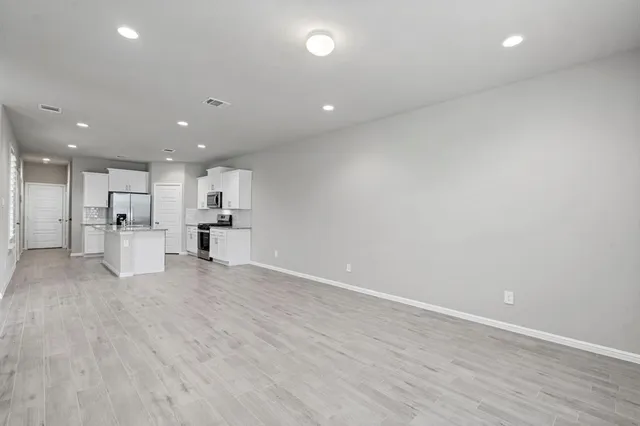 a view of kitchen with kitchen island and stainless steel appliances