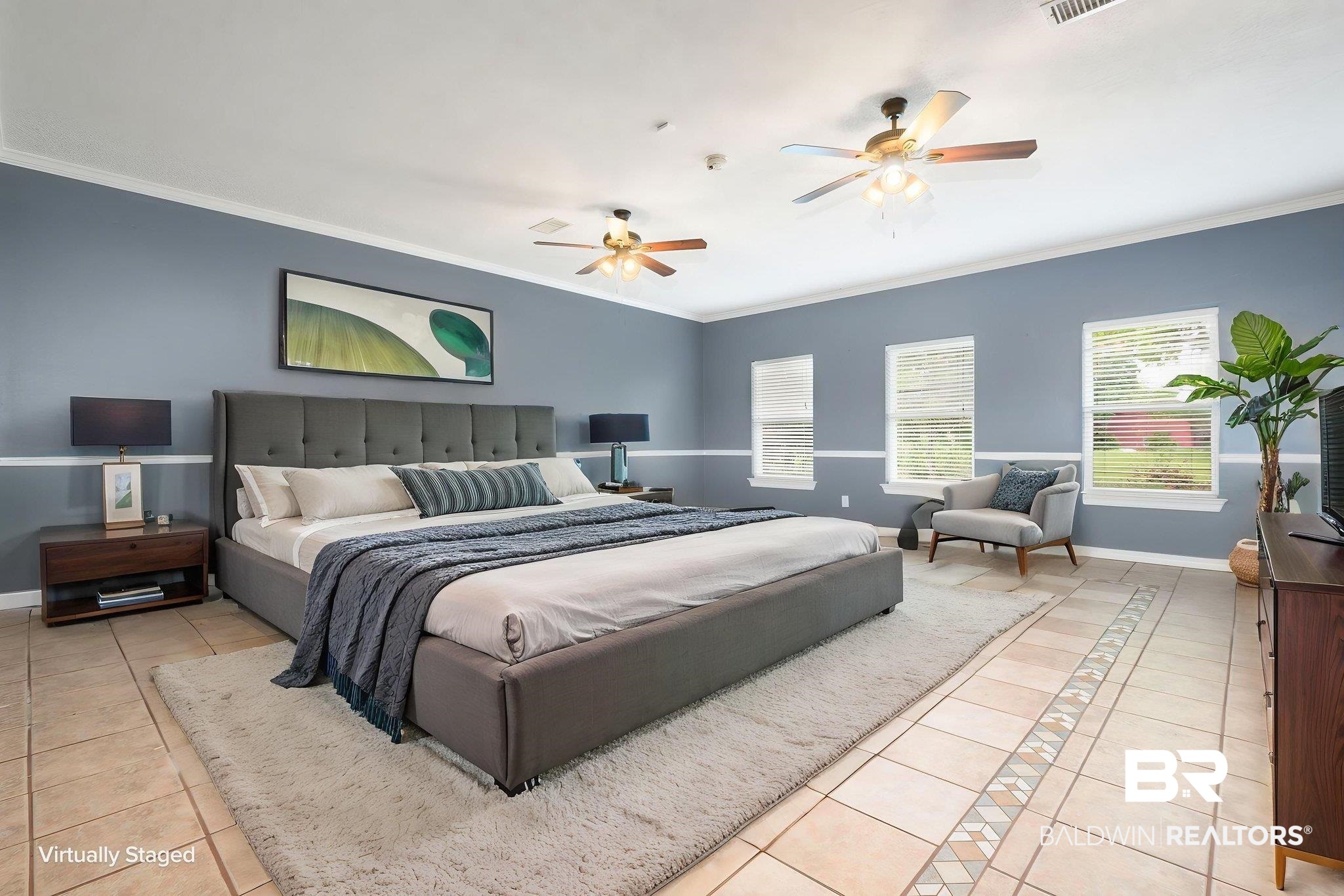 7540 2 Mile Road Irvington, AL 36544 - Photo 7 of 82 Spacious room featuring tile flooring with decorative inlay, multiple windows, two ceiling fans with light fixtures, and crown molding