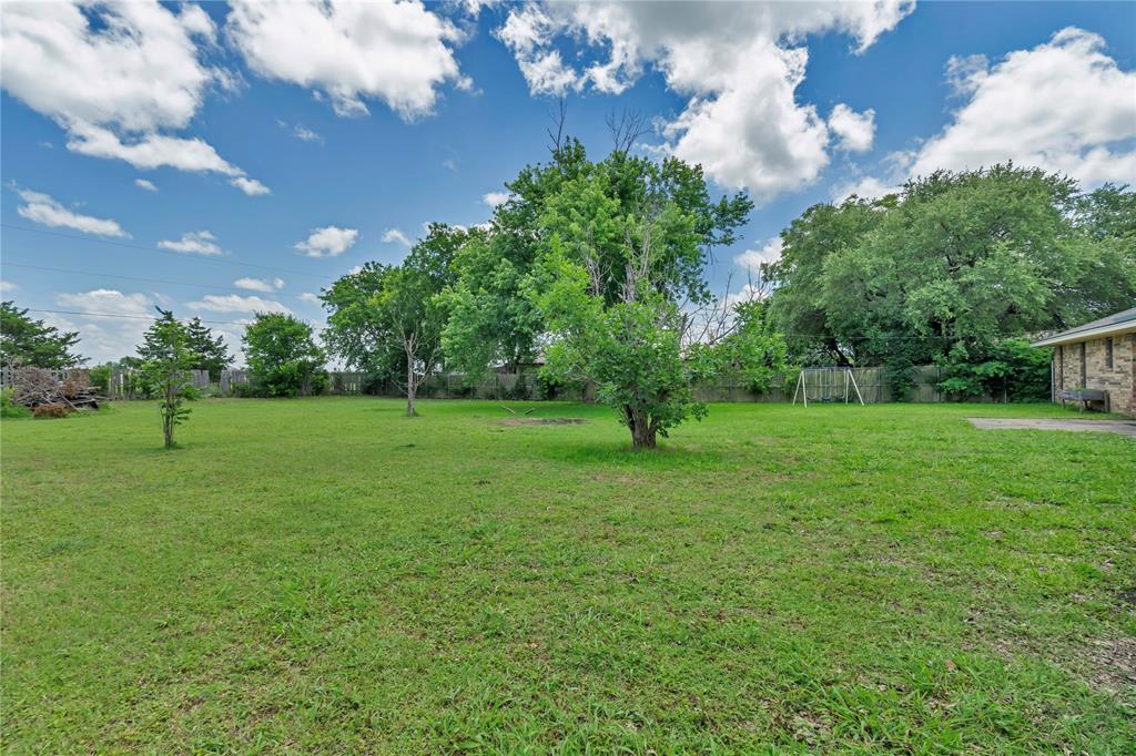 108 Prairie Creek Road Red Oak, TX 75154 - Photo 16 of 19 Expansive green lawn with mature trees and a partial brick exterior