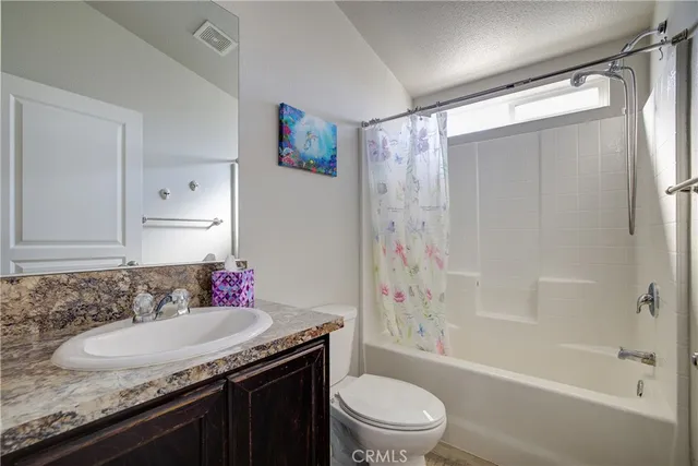 a bathroom with a granite countertop sink a toilet and shower