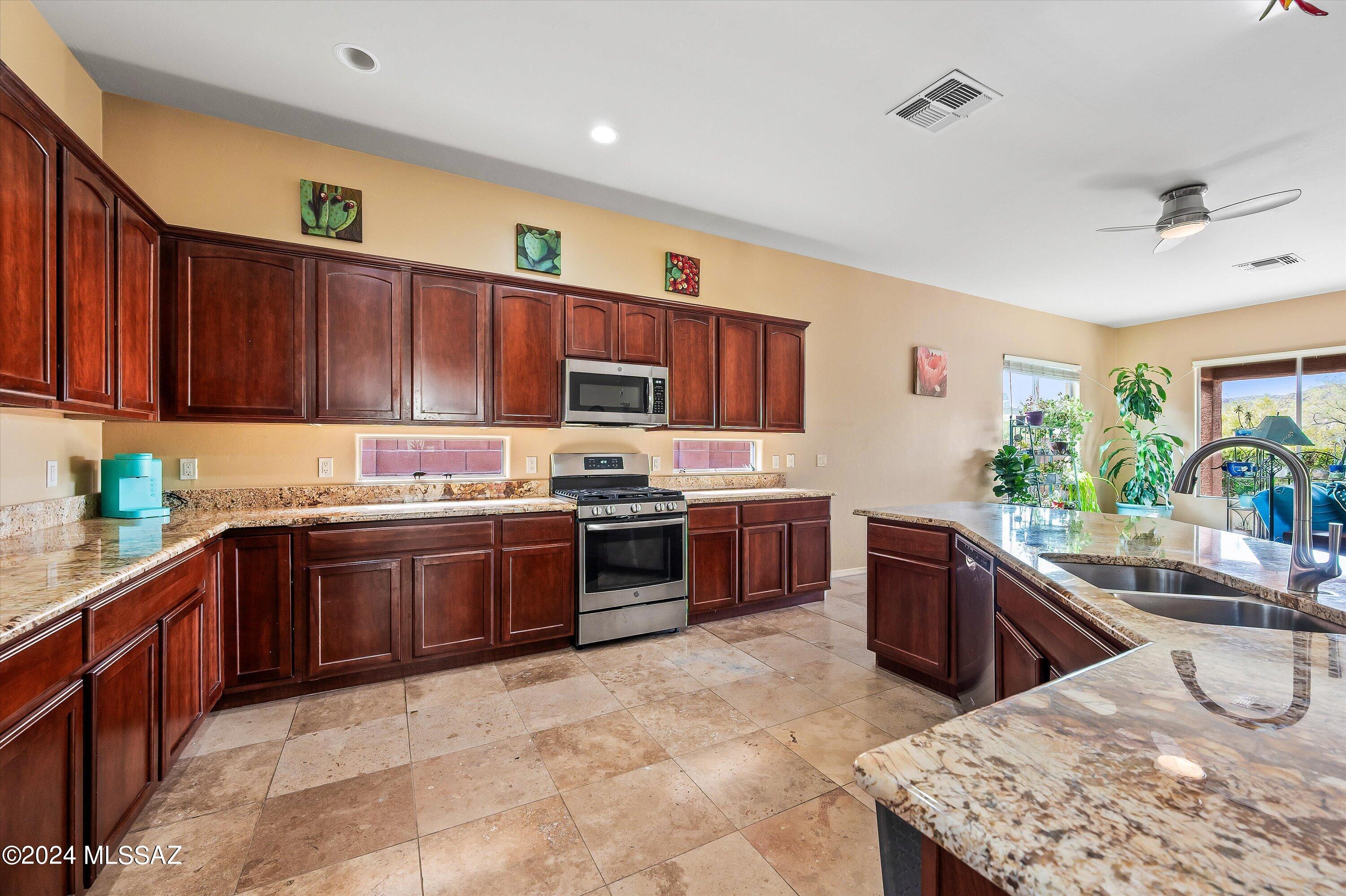 8579 North Shadow Wash Way Tucson, AZ 85743 - Photo 8 of 34 a kitchen with stainless steel appliances granite countertop a stove sink and cabinets