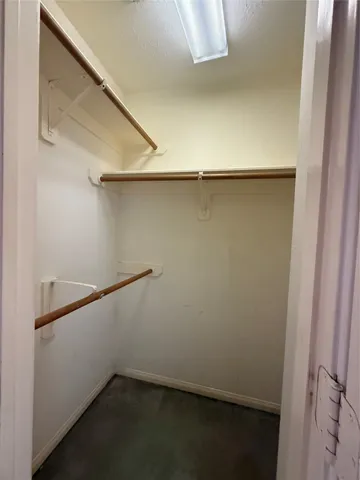 an empty room with windows and ceiling fan