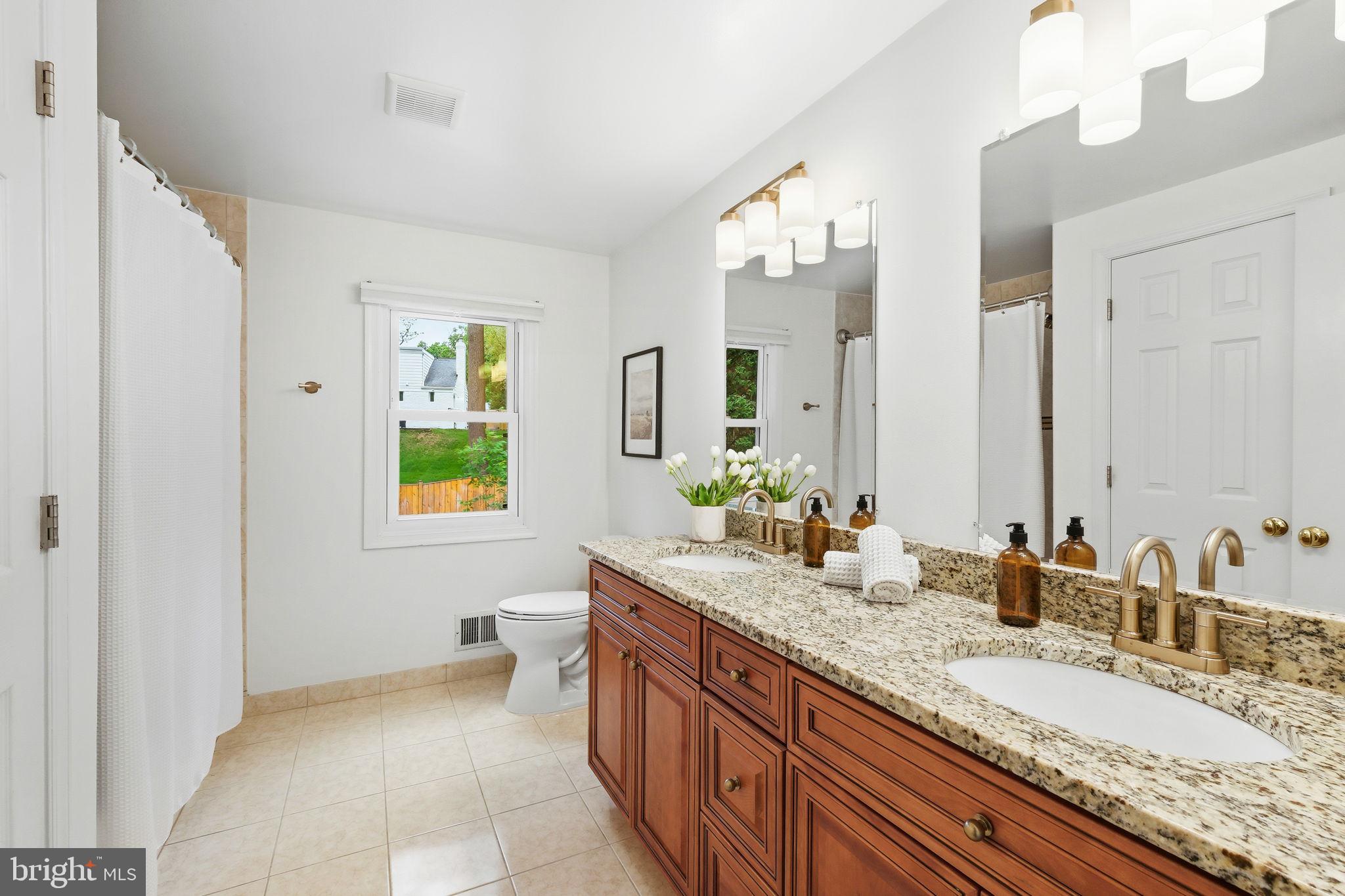 10900 Gainsborough Road Potomac, MD 20854 - Photo 32 of 44 a bathroom with a granite countertop double vanity sink and a mirror