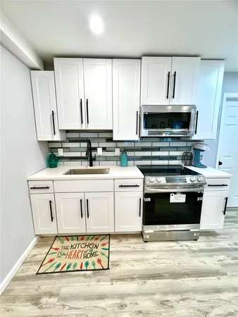 a kitchen with stainless steel appliances a stove a sink and a microwave