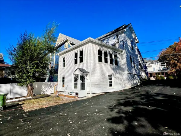 a view of a white house with a yard