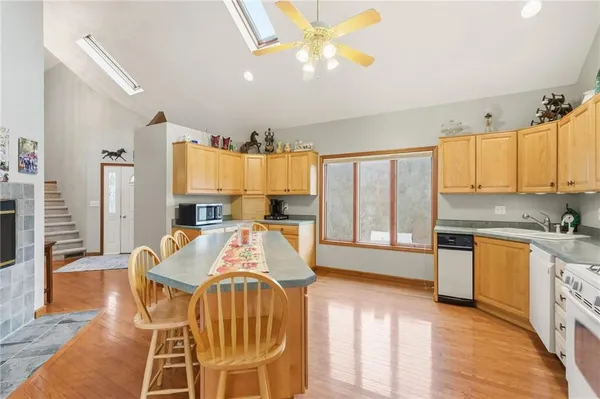 a very nice looking kitchen with granite countertop a large window cabinets and stainless steel appliances