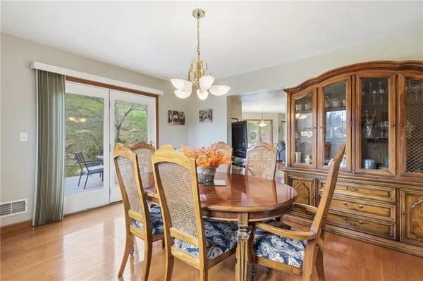 a dining room with furniture a chandelier and wooden floor
