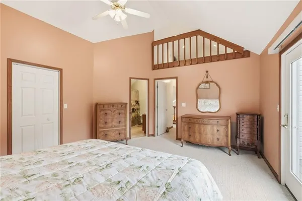 a bedroom with a bed a mirror and dresser with wooden floor