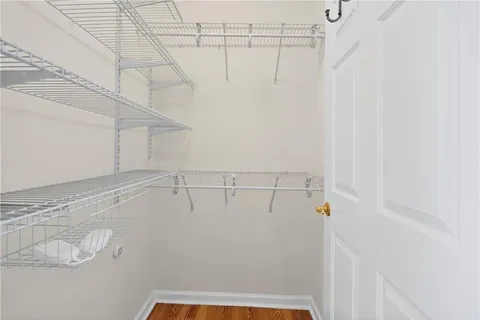 a room with lots of wooden furniture a large window and stainless steel appliances