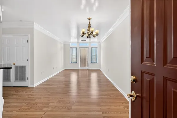 a view of a room with a chandelier fan and wooden floor