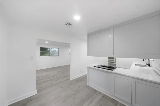 a kitchen with granite countertop a sink and cabinets