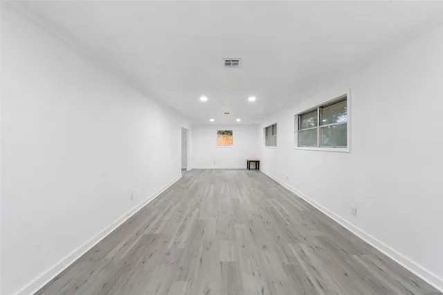 a view of empty room with wooden floor