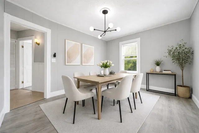 a dining room with furniture potted plants and wooden floor