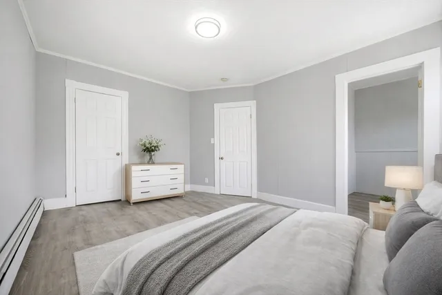a bedroom with a white bed and dresser