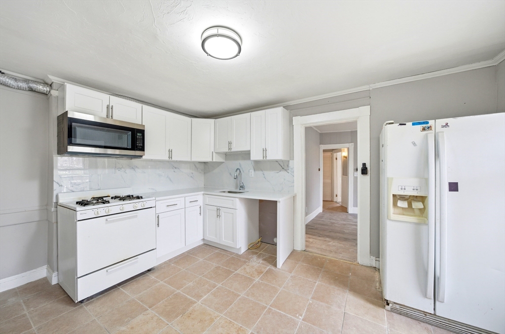 29-31 Auburn Street, Unit 2L Everett, MA 02149 - Photo 2 of 18 a kitchen with stainless steel appliances granite countertop a refrigerator and a stove top oven