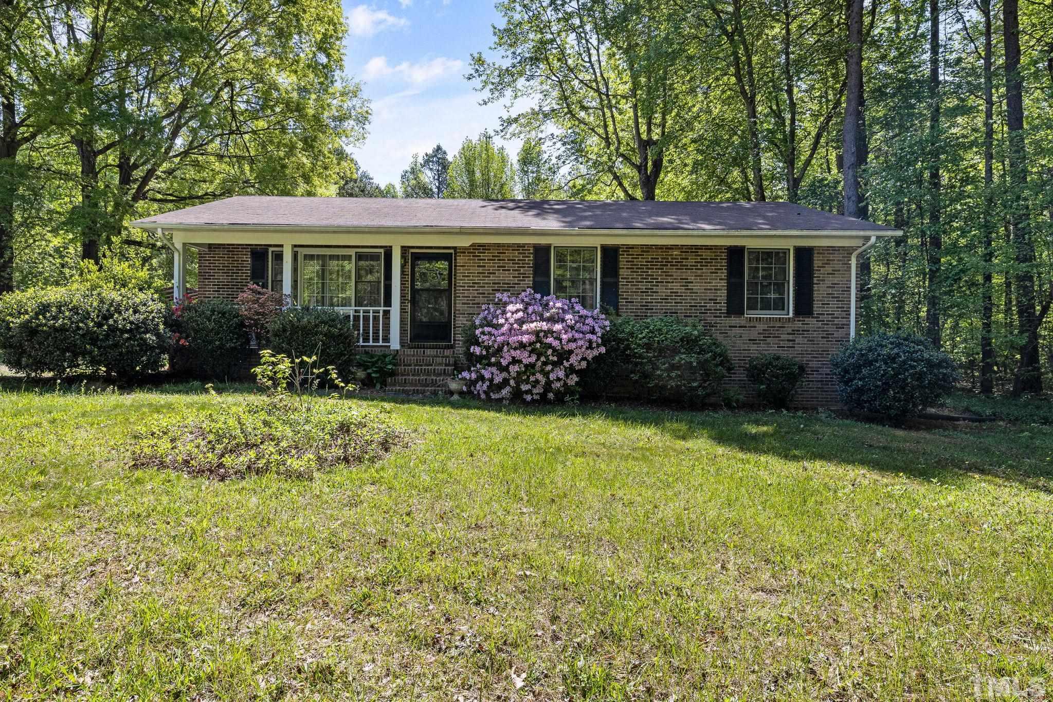 3509 Hurdle Mills Road Roxboro, NC 27574 - Photo 1 of 30 a front view of a house with garden