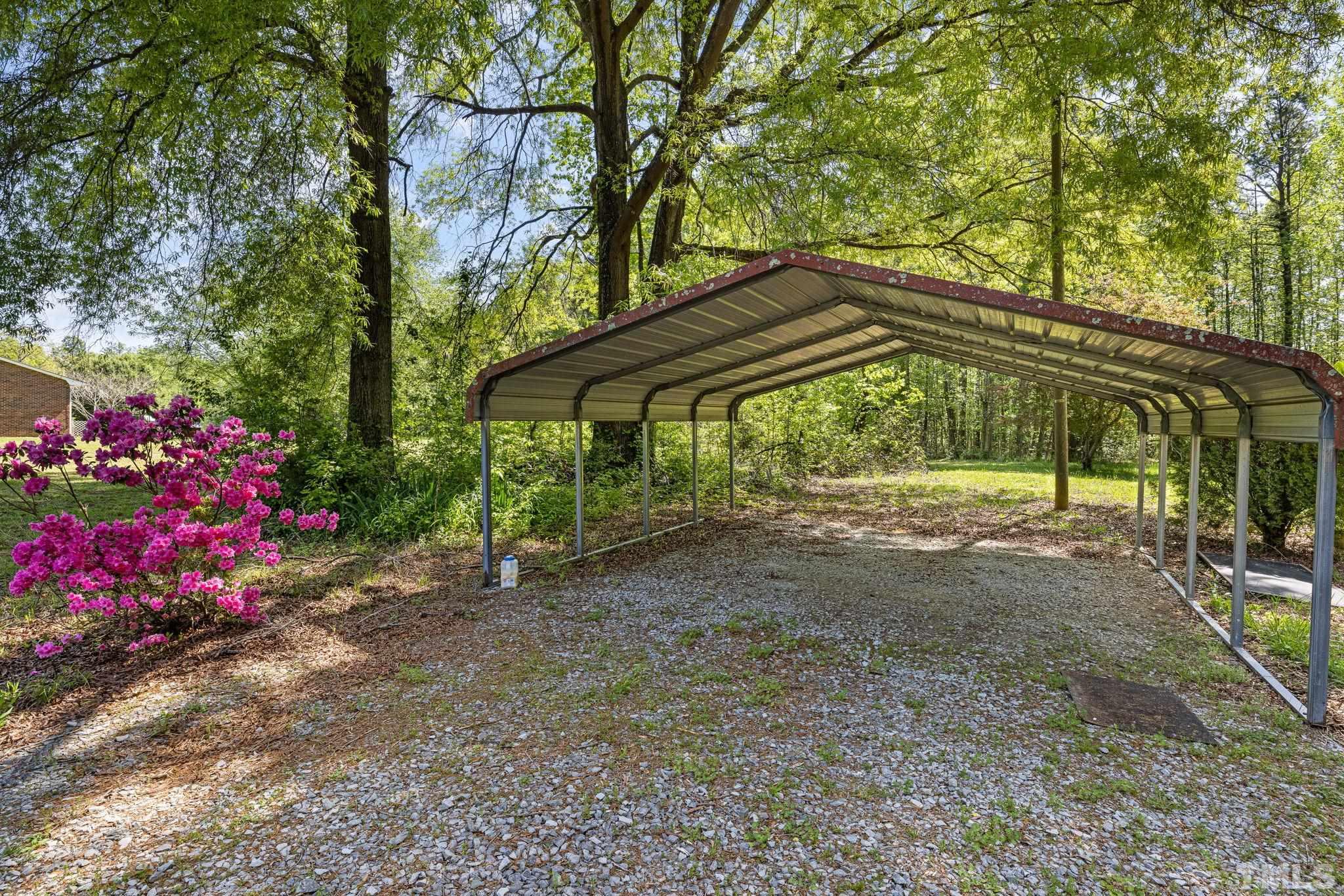 3509 Hurdle Mills Road Roxboro, NC 27574 - Photo 5 of 30 a backyard of a house with table and chairs under an umbrella