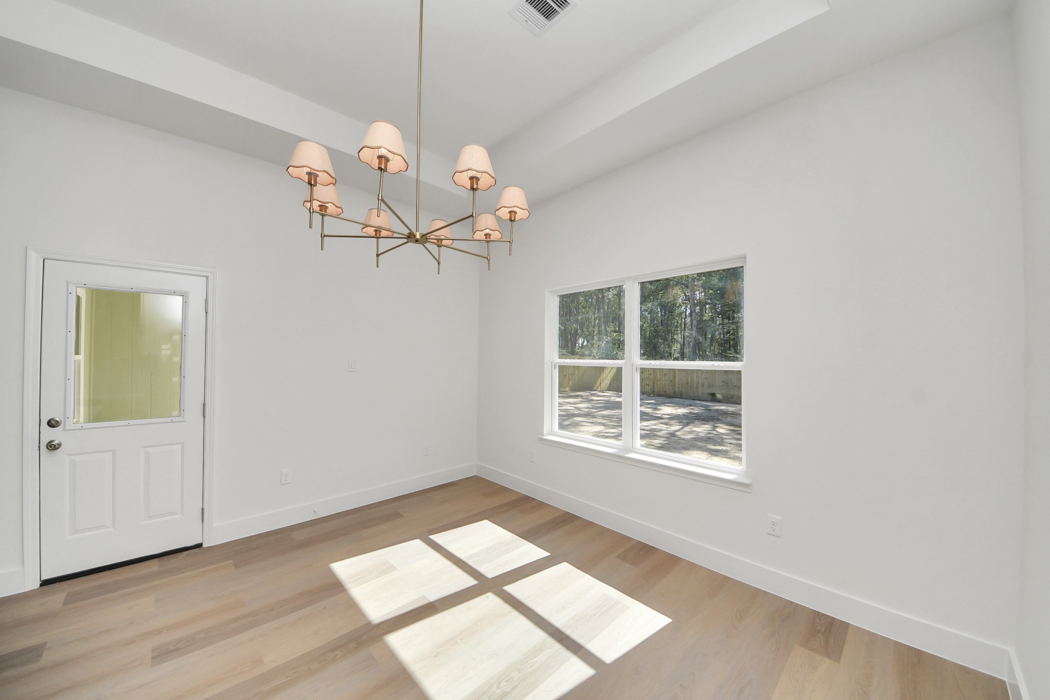 16280 Jeet Street Conroe, TX 77306 - Photo 19 of 44 a view of an empty room with a window and wooden floor