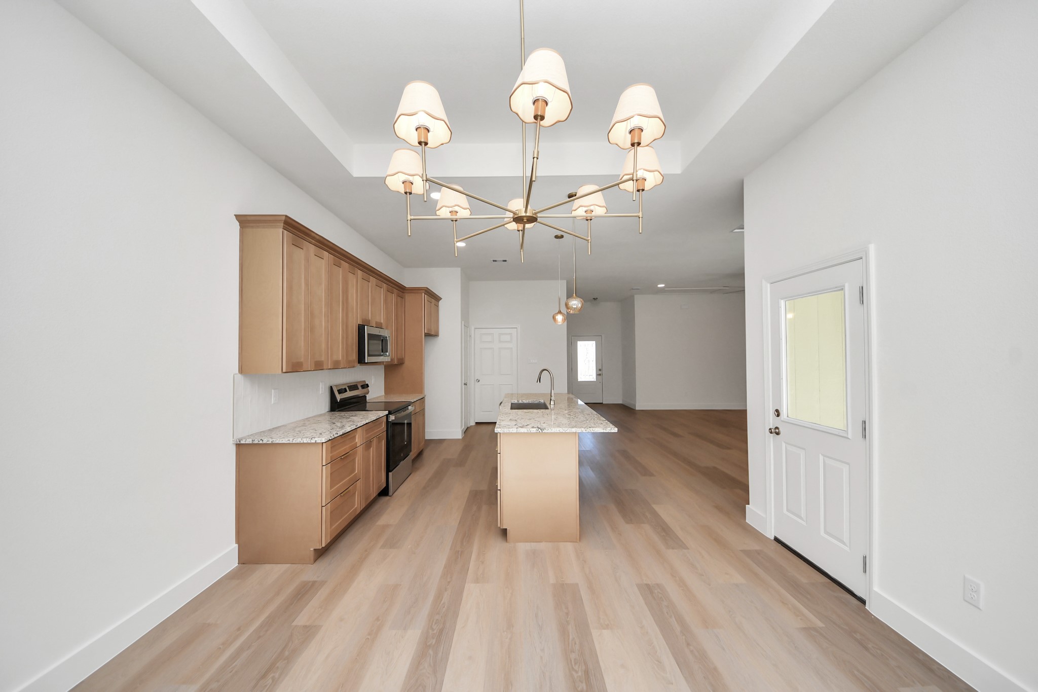 16280 Jeet Street Conroe, TX 77306 - Photo 21 of 44 a view of a kitchen with a sink dishwasher granite counter tops and a view of living room