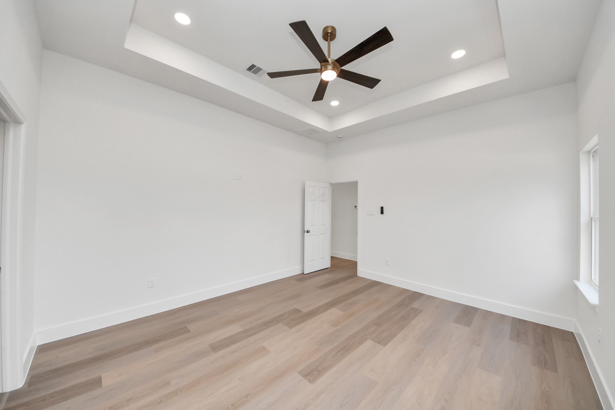 16280 Jeet Street Conroe, TX 77306 - Photo 24 of 44 an empty room with wooden floor and ceiling fan