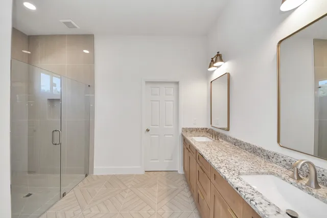 a spacious bathroom with a granite countertop sink and a mirror